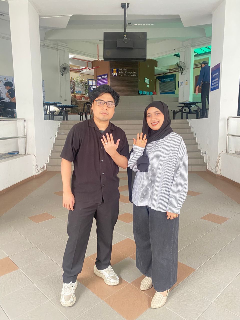Athirah and Syamir showing their engagement rings at UiTM